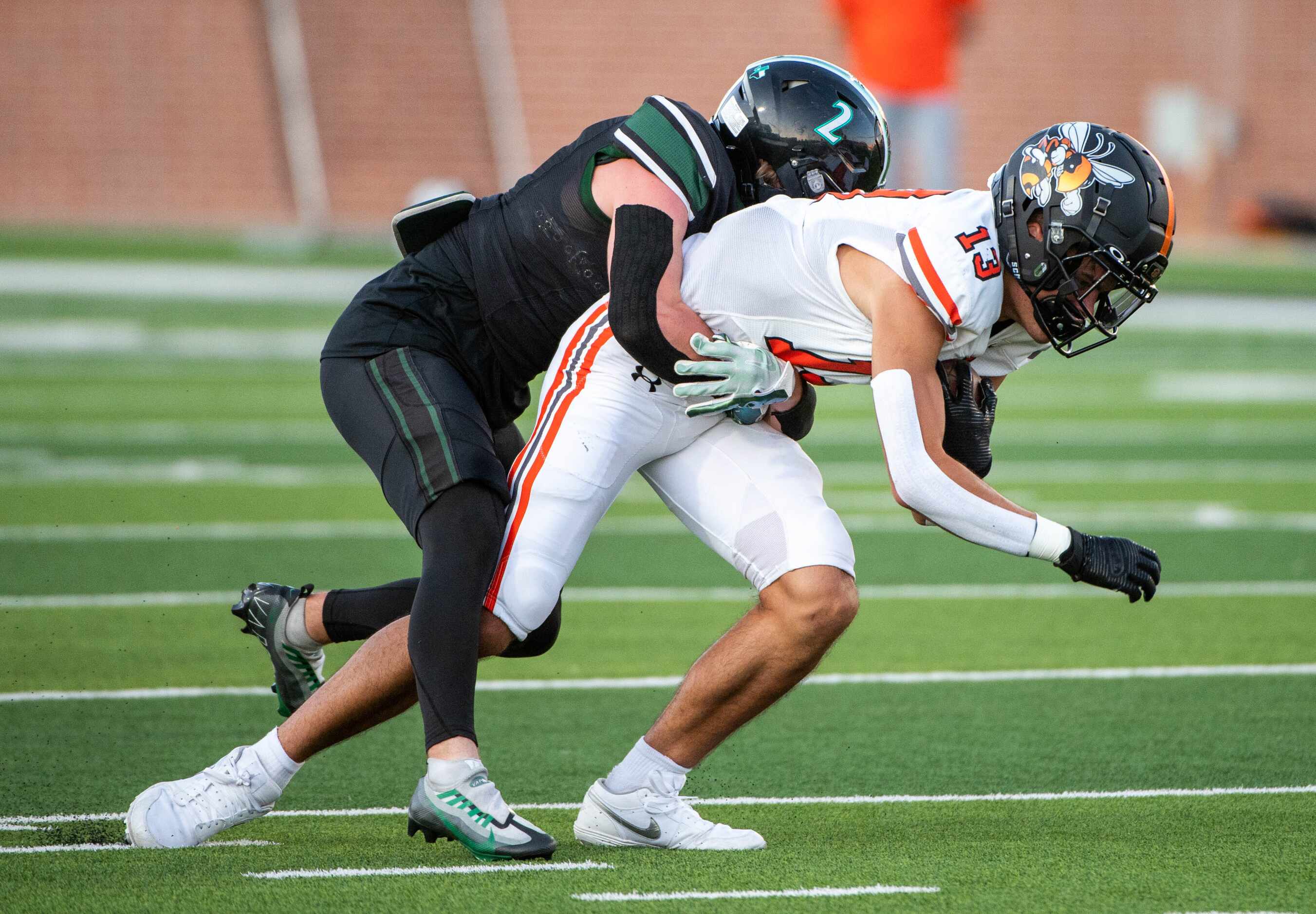 Rockwall's wide receiver Kai Helton (13) tries to run through a tackle attempt by Prosper's...