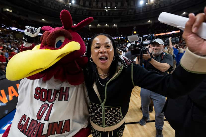 South Carolina head coach Dawn Staley celebrates with the South Carolina mascot "Cocky"...