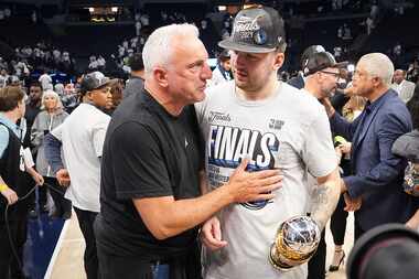 Dallas Mavericks guard Luka Doncic holds the MVP trophy as he talks with  his father, Sasa...