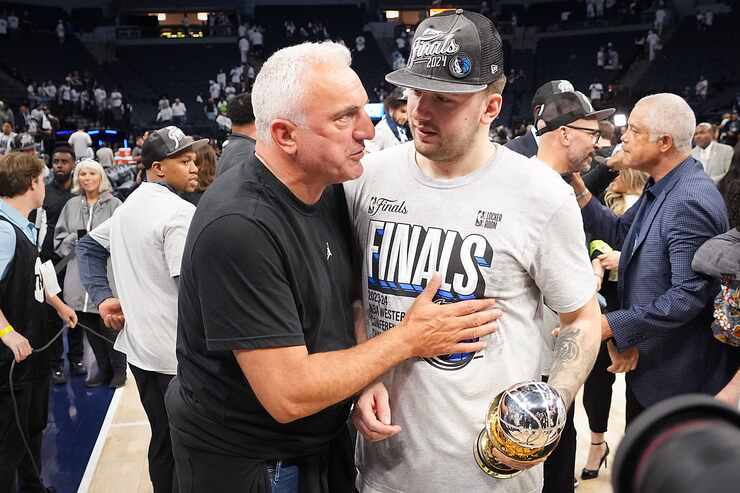 Dallas Mavericks guard Luka Doncic holds the MVP trophy as he talks with  his father, Sasa...