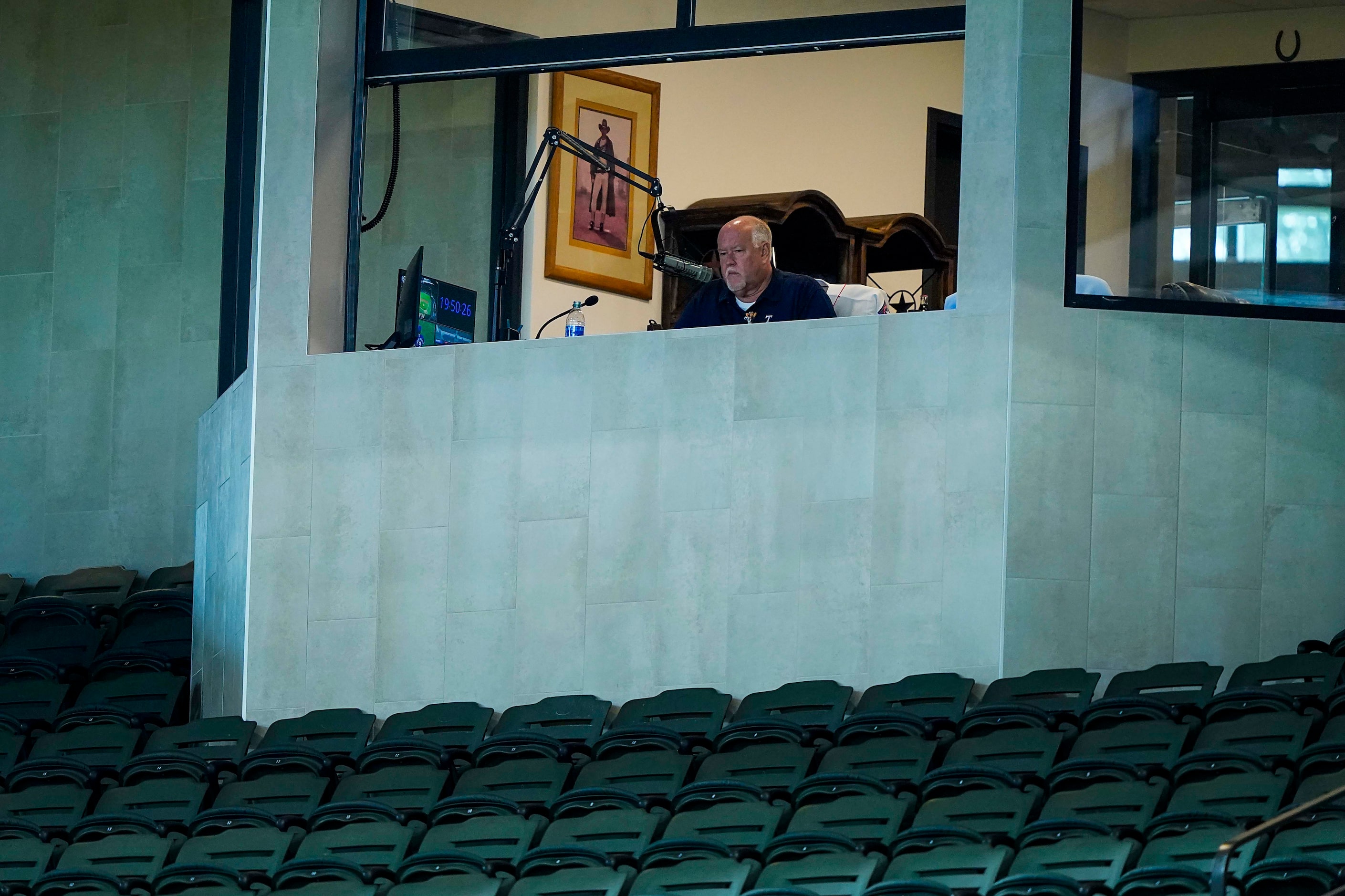 Announcer Chuck Morgan works in his booth during Texas Rangers Summer Camp at Globe Life...