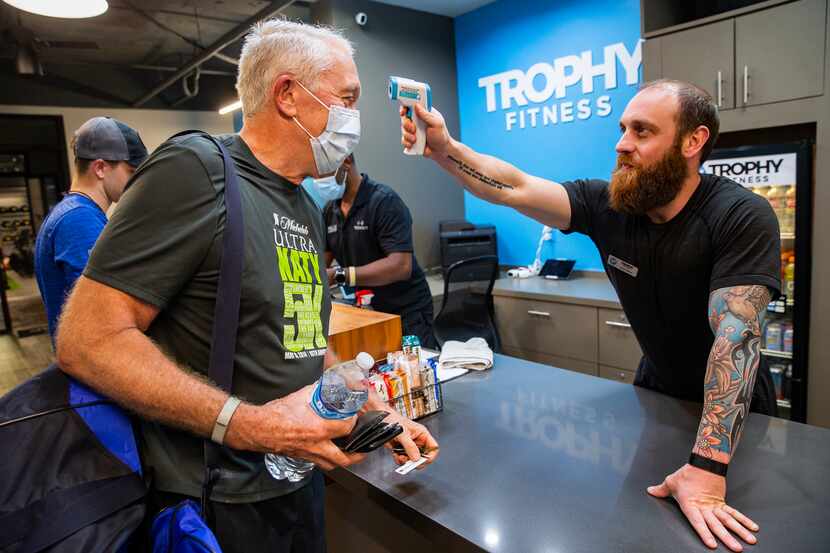 Client Durward Watson of Oak Lawn (left) has his temperature taken by a Trophy Fitness...