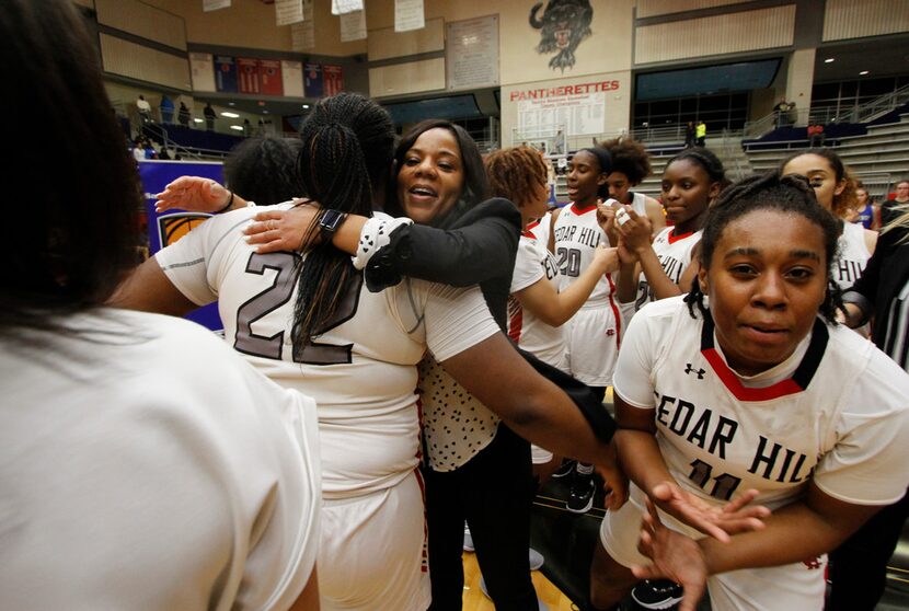 Cedar Hill head coach Nicole Collins shares a hug with forward Taylor Hutchins (22)...