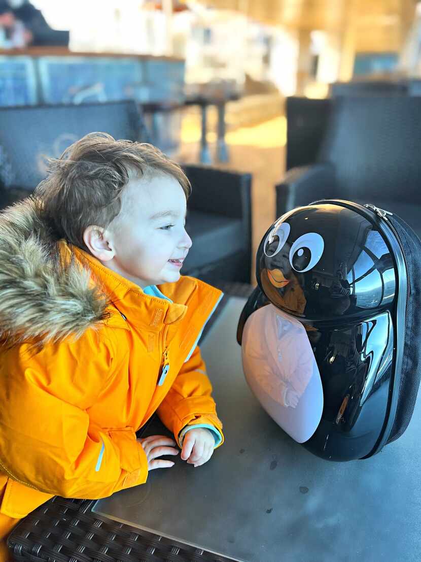 Max Smith, 2, plays with a toy penguin as he heads to Antarctica.