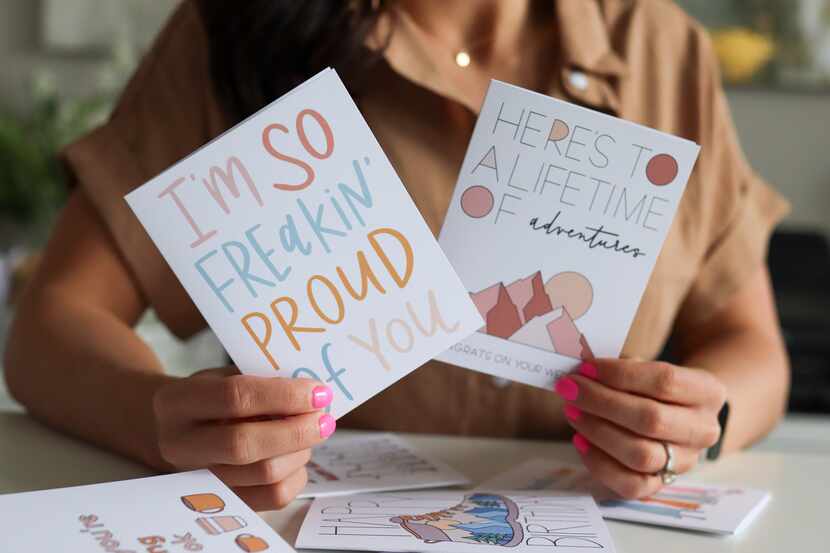 Megan Kuhn holds two greeting cards with encouraging sayings