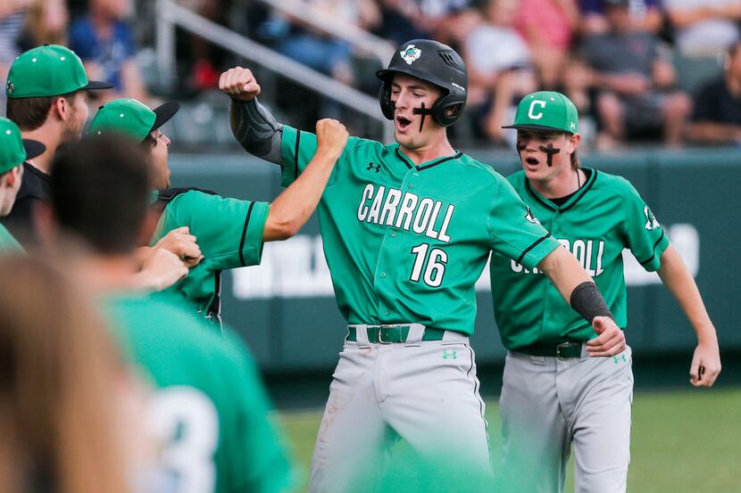 Southlake Carroll's Austin Hale (16) is congratulated by teammates after scoring on a wild...