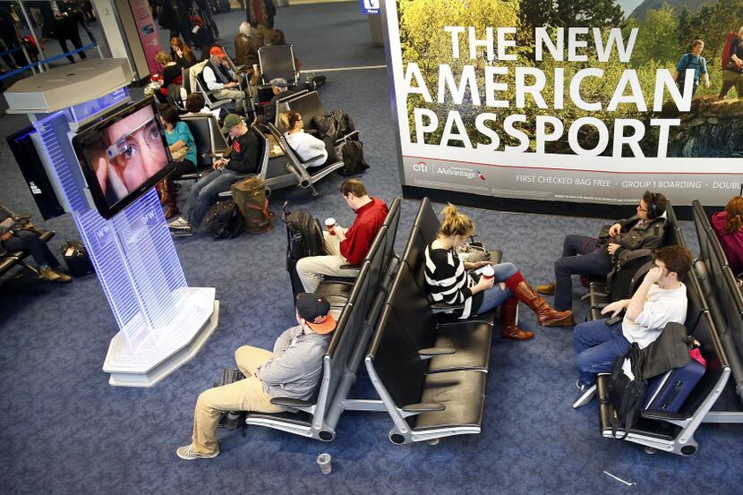 Passengers wait for their flight in Terminal A at Dallas Fort Worth International Airport,...