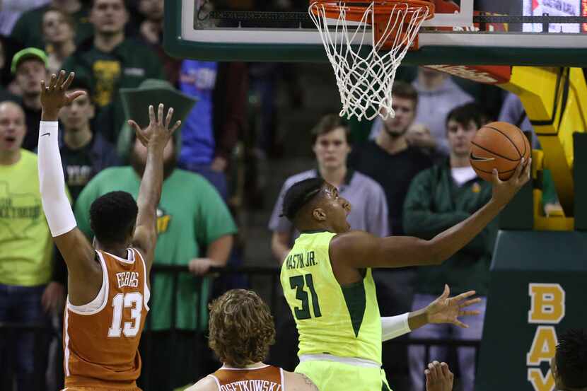 Baylor forward Terry Maston, right, scores past Texas guard Jase Febres, left, in the first...