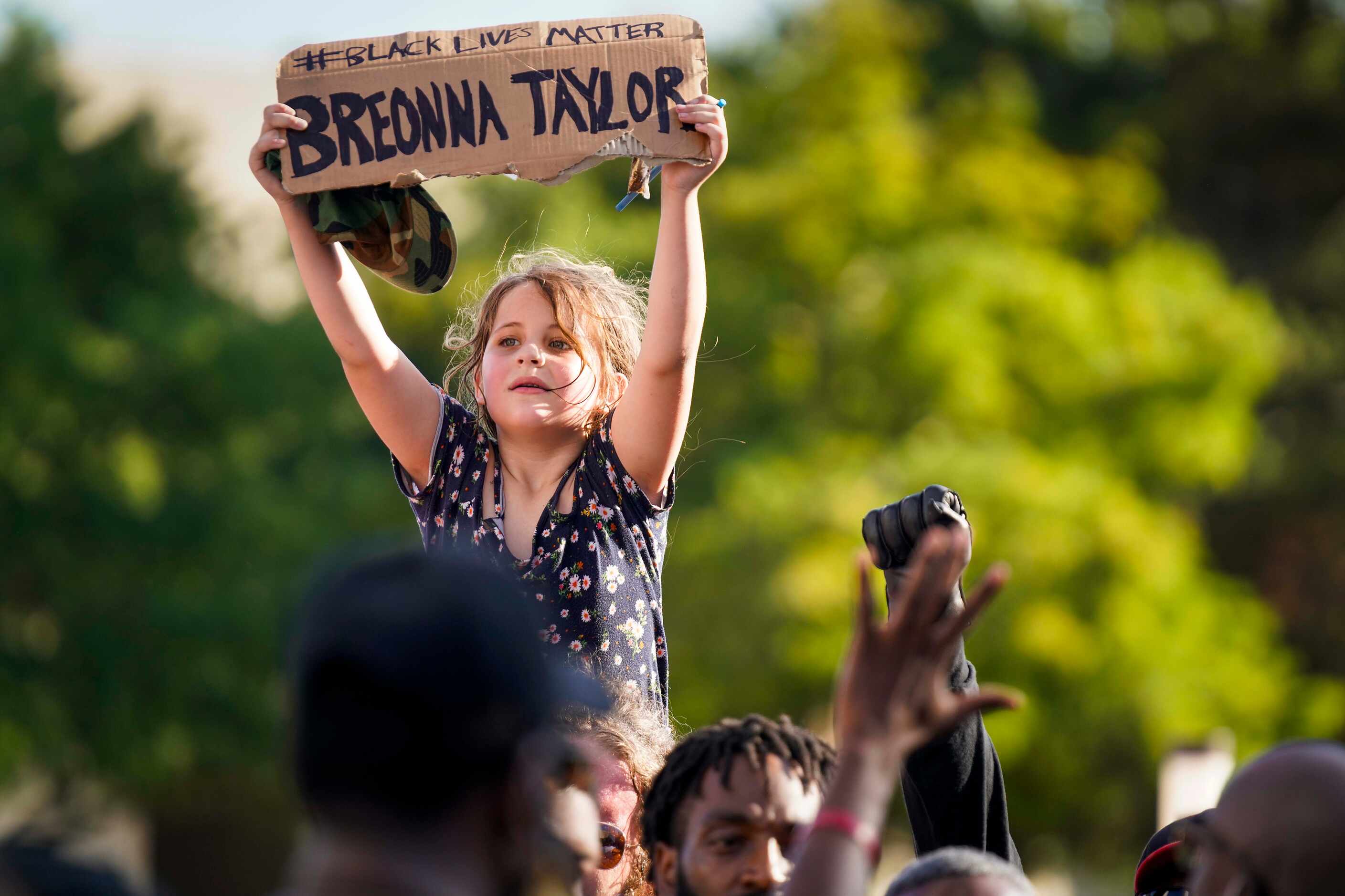 A young girl holds a sign in remembrance Breonna Taylor during a rally of the Greeks United...