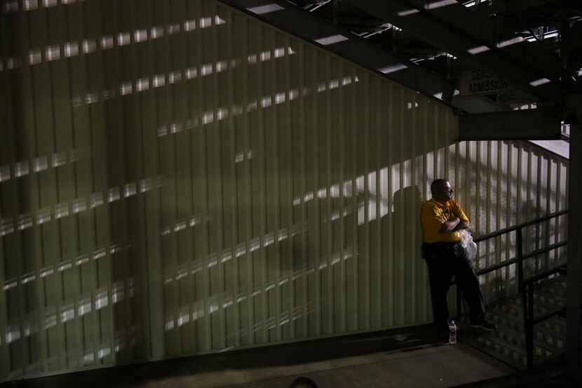 Event security Kim Koop watches from the tunnel during a weather delay as severe weather...