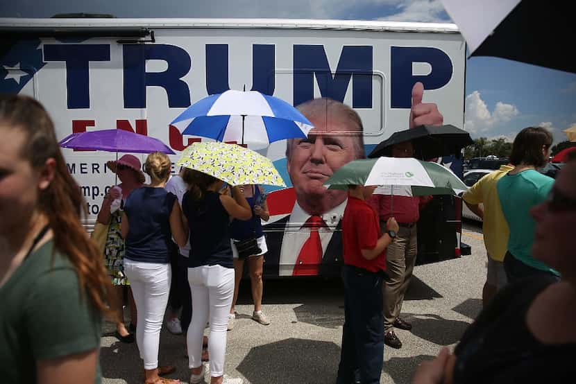 People wait in line to see Republican presidential candidate Donald Trump speak during a...