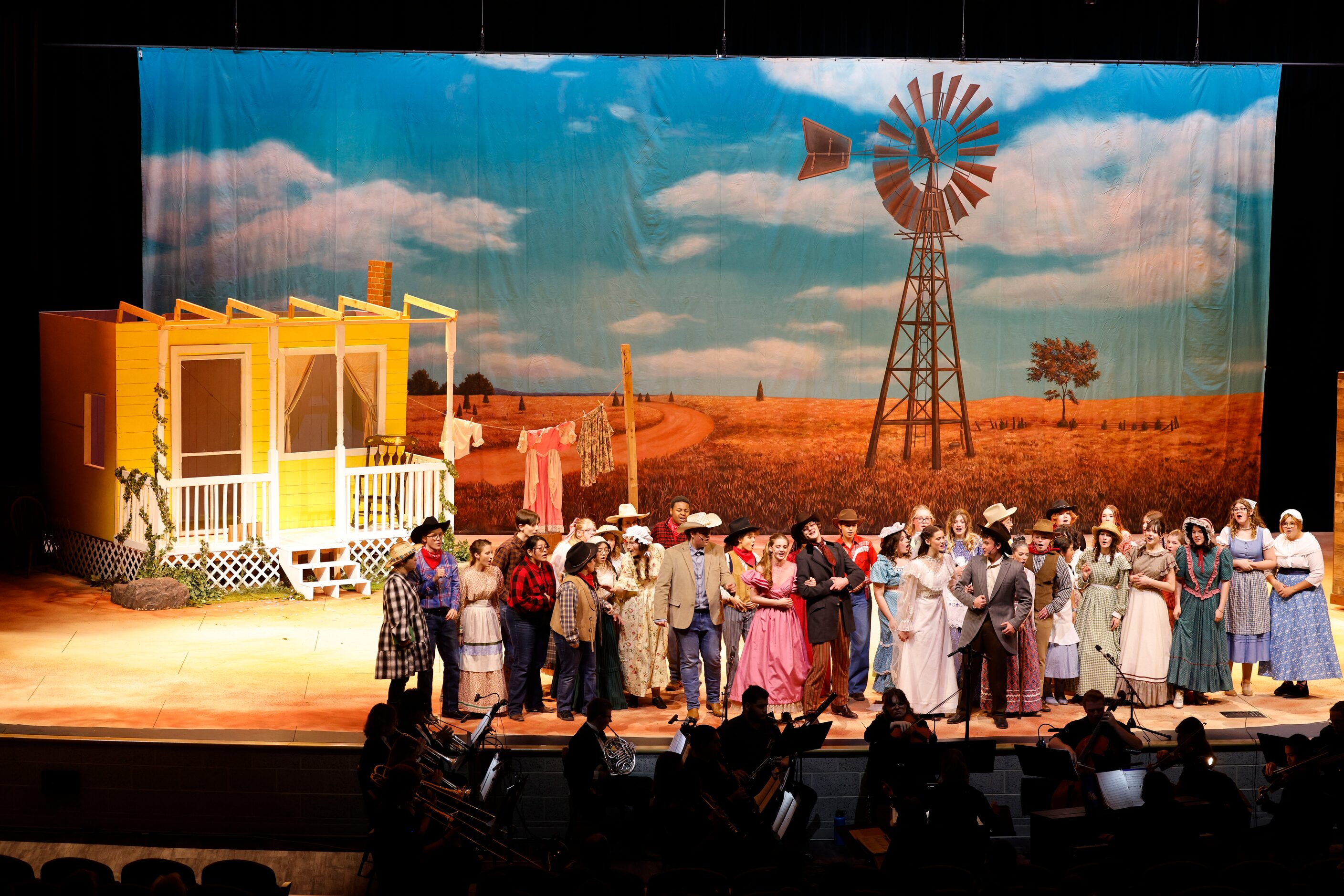 Cast members act during the opening night of the Sherman High School production of Oklahoma!...