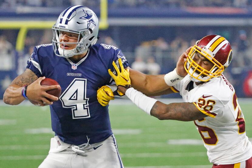 Dallas Cowboys quarterback Dak Prescott (4) stiff-arms Washington Redskins cornerback...