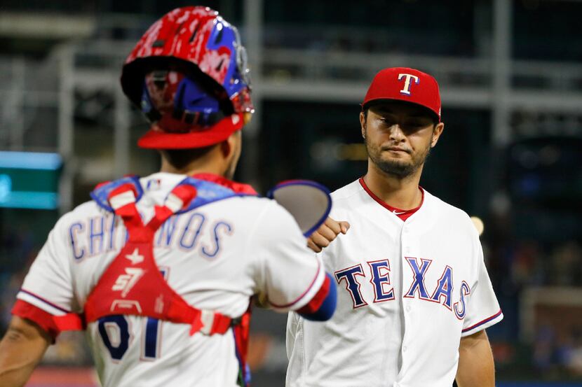 Rangers catcher Robinson Chirinos (left) and Yu Darvishwalk to the dugout after the top of...
