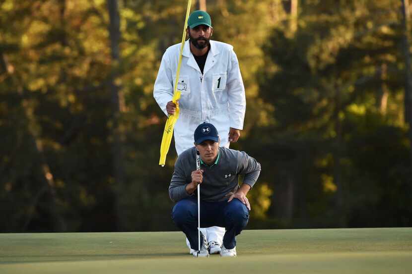 US golfer Jordan Spieth lines up putt on the 18th green during Round 3 of the 80th Masters...