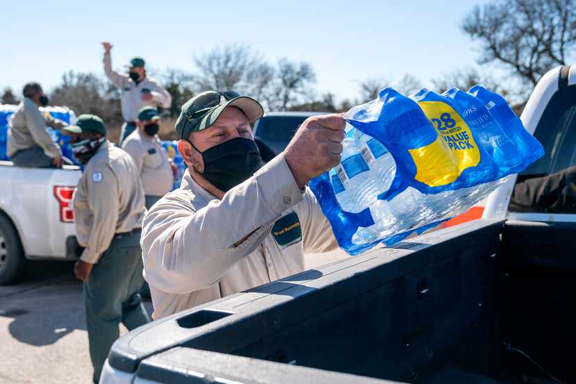 Jesus Muñiz loaded a case of bottled water in a pickup, Monday, February 22, 2021, during a...