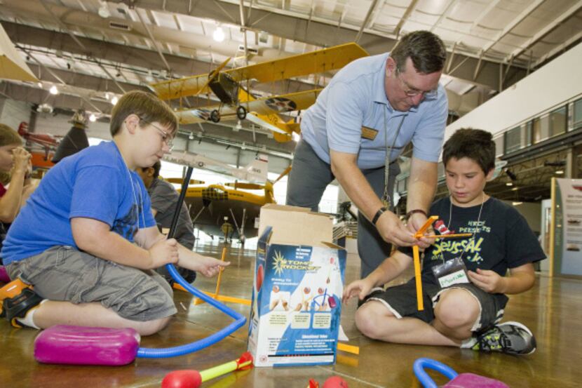 Education Coordinator Bob Welch helps Marcus Manriquez, 10, assemble the launch pad for a...