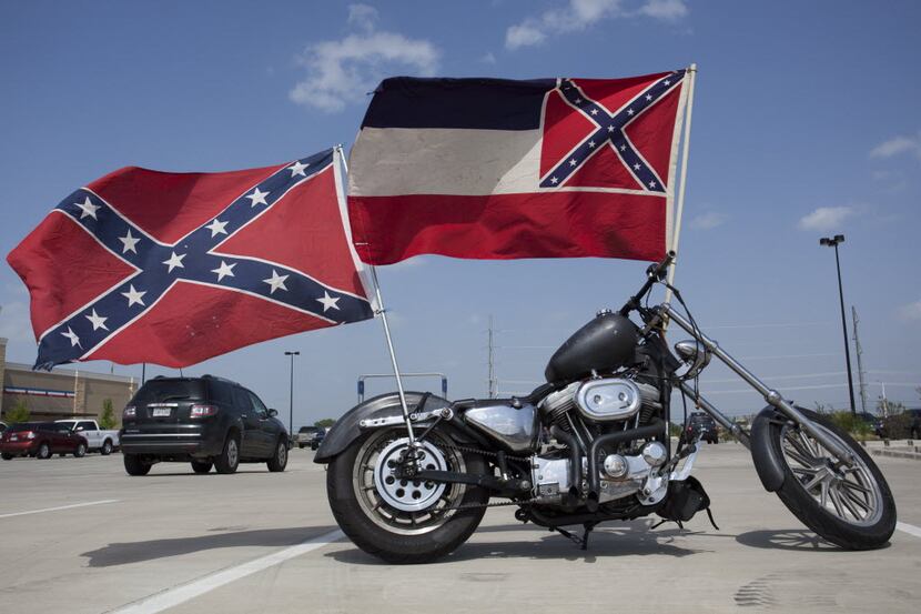 Confederate flags fly from a motorcycle in the Academy parking lot in Denton in this file...