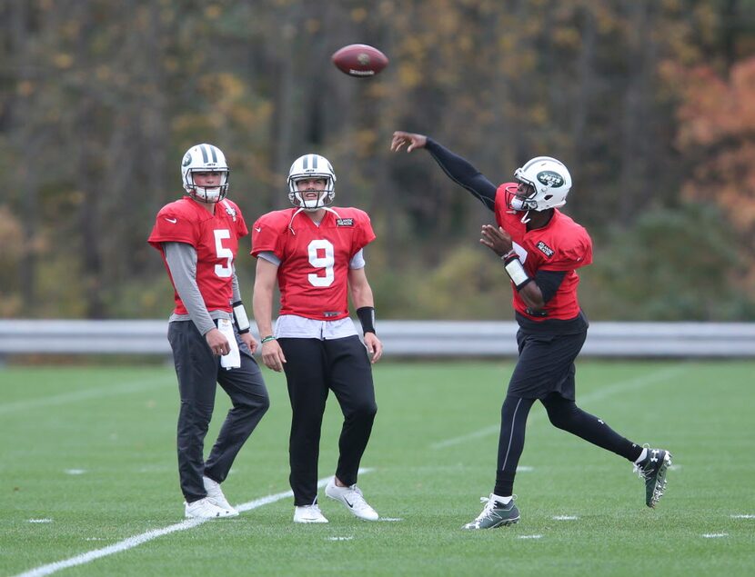 New York Jets quarterback Geno Smith, right, throws while quartebacks Christian Hackenberg,...