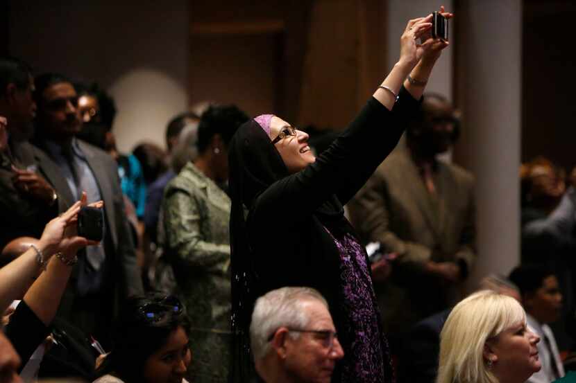 Zulikha Hussain takes a photo during a meeting at the Dallas County Commissioners Court in...