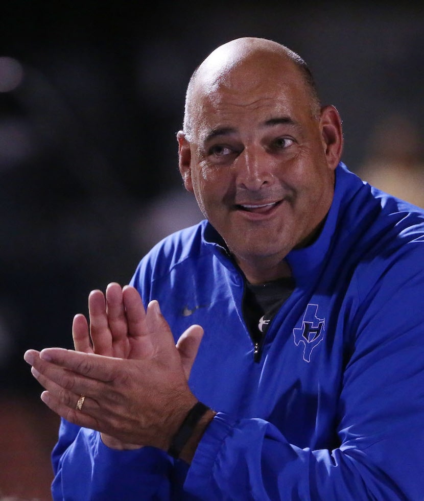 Hebron head coach Brian Brazil congratulates his team following a high school football game...