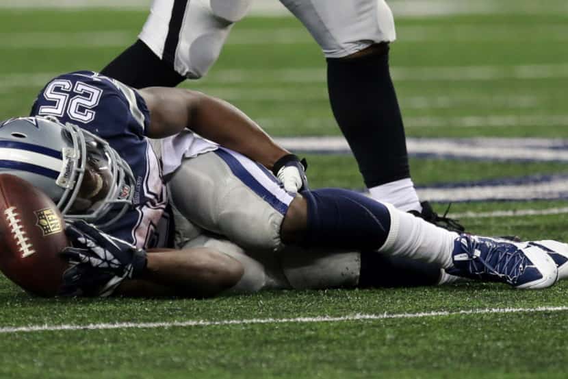 Dallas Cowboys running back Lance Dunbar (25) grabs his leg after being injured to end a...