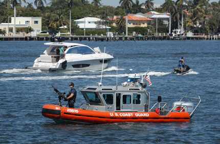 U.S. Coast Guard patrol, watch Lake Worth Lagoon as President Donald Trump returns to his...