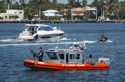 U.S. Coast Guard patrol, watch Lake Worth Lagoon as President Donald Trump returns to his...