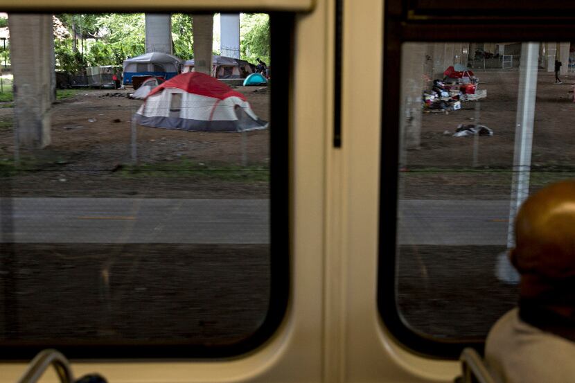 Tents and people in a homeless encampment under I-30 at Haskell Avenue can be seen from the...