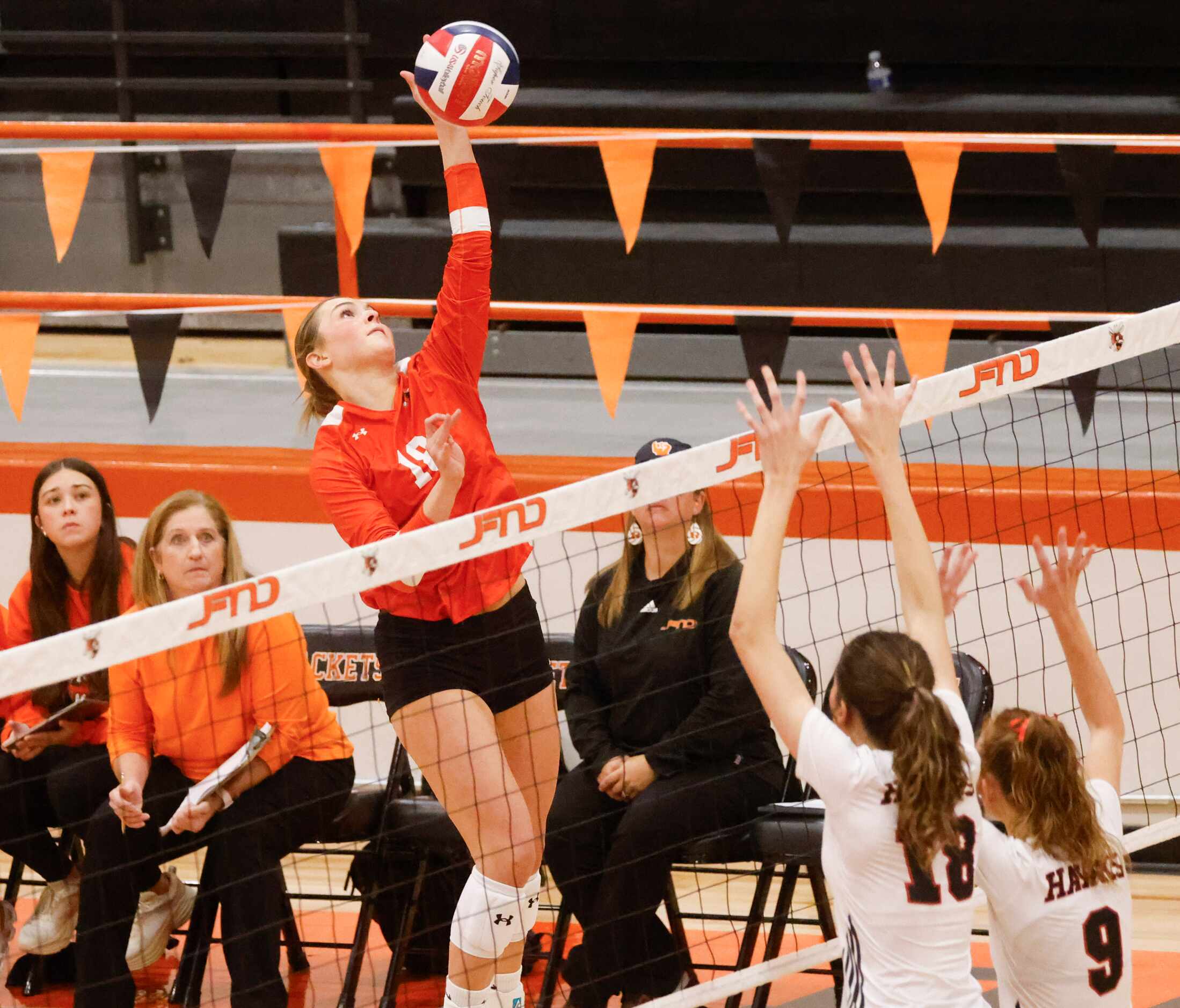 Rockwall high’s Janie Deapen spikes the ball against Rockwall heath’s Abby Lemp (18) and...