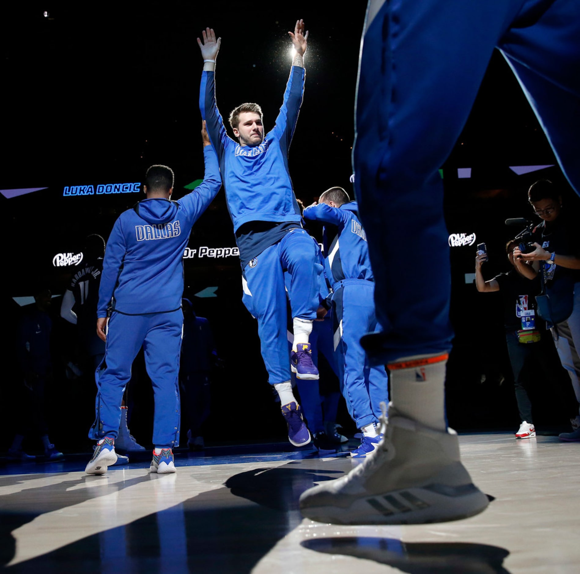 Dallas Mavericks forward Luka Doncic (center) is welcomed by teammates as he's introduced...