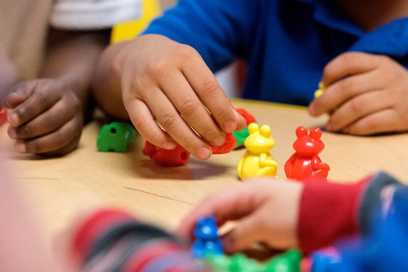Preschoolers complete patterns during an activity with their teacher on Friday, December 9,...