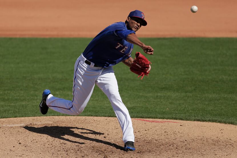 Texas Rangers relief pitcher Alexi Ogando throws during the fifth inning of an exhibition...