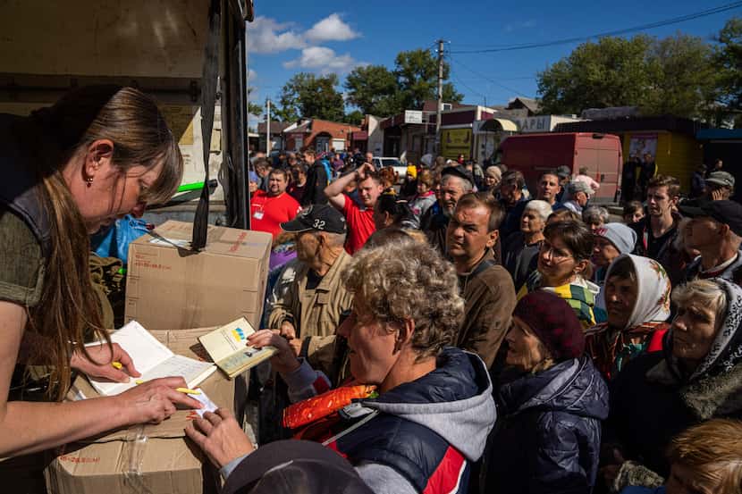 People receive packages from their relatives in the recently retaken area of Izium, Ukraine,...