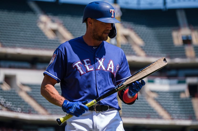 Texas Rangers outfielder Hunter Pence looks at  his shattered bat as he heads to the dugout...