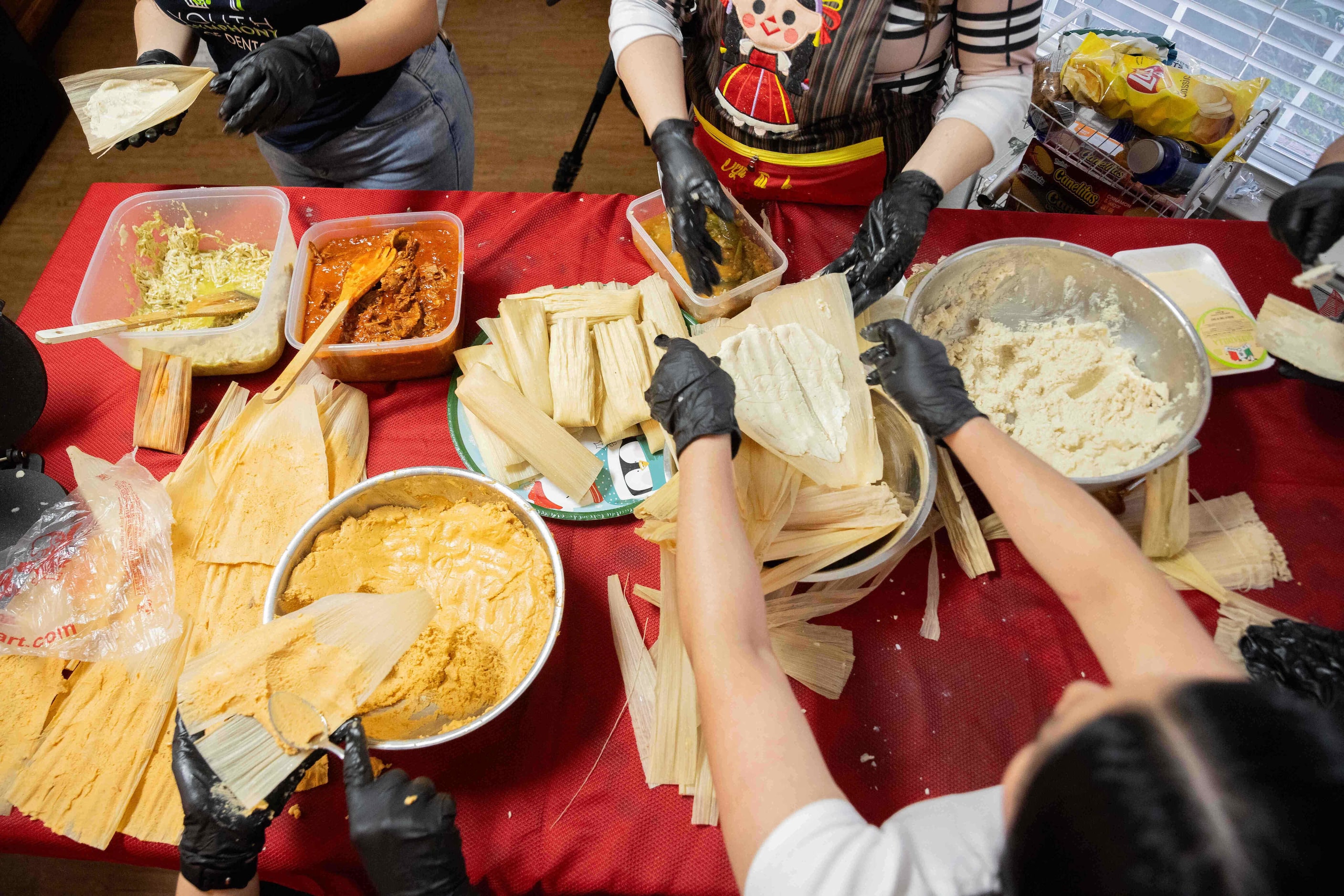 Chosen family help Sara Klein, the hostess behind the evening’s “tamalada,” prepare tamales...