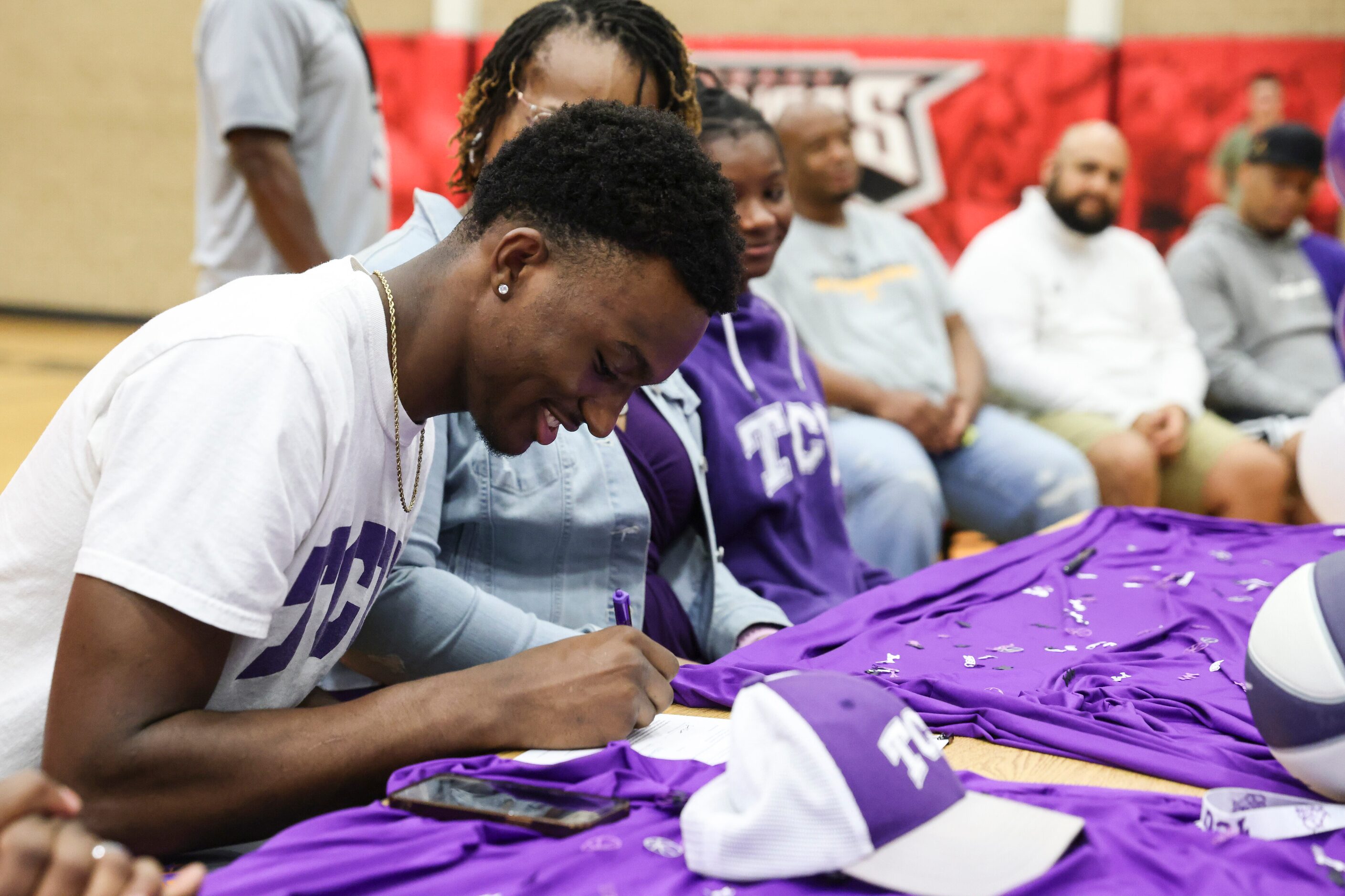 Isaiah Manning signs his name commiting to play basketball at Texas Christian University...