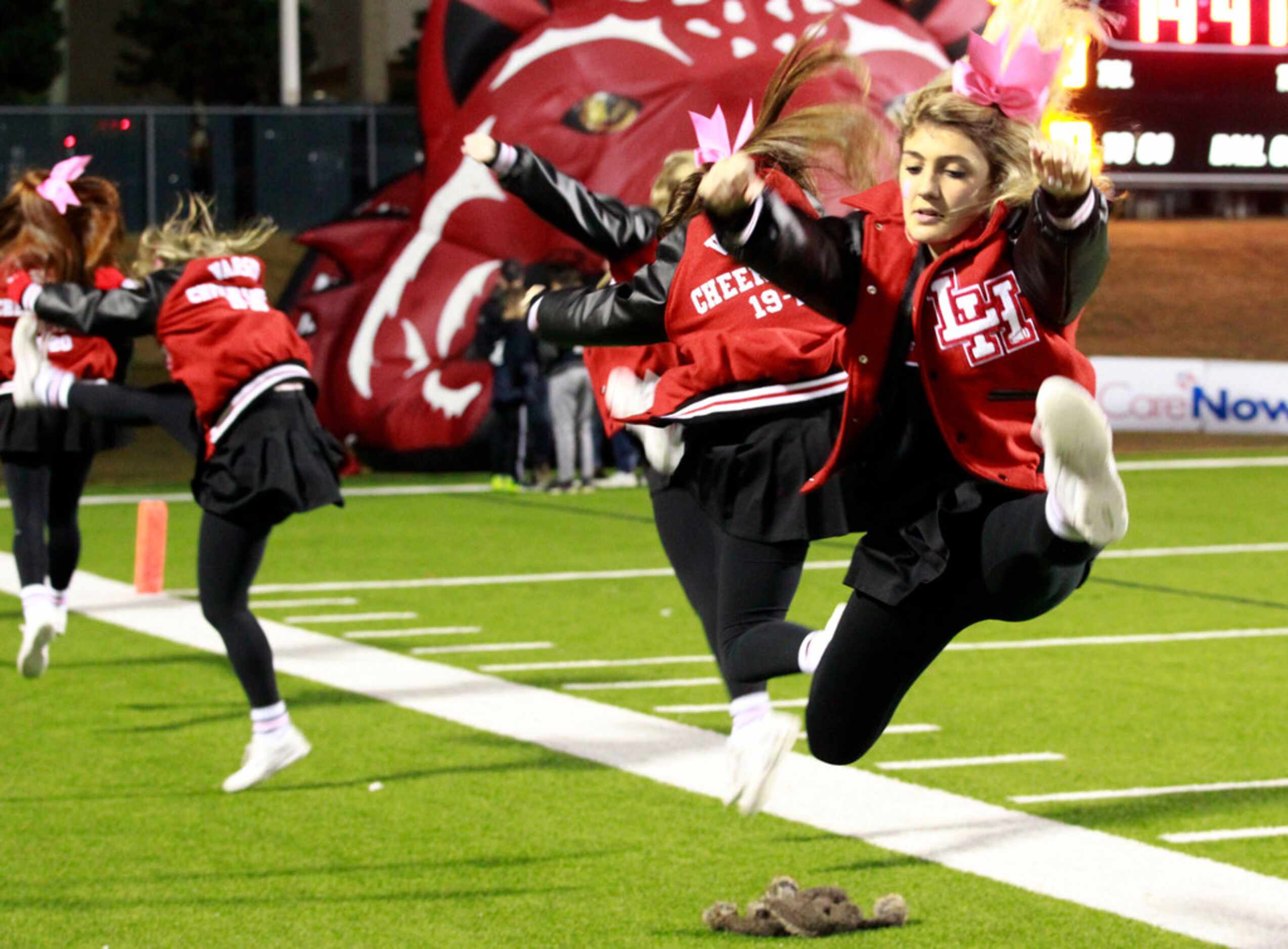 Lake Highlands cheerleader Sally Jacobs, a junior, performs a practice jump before the first...