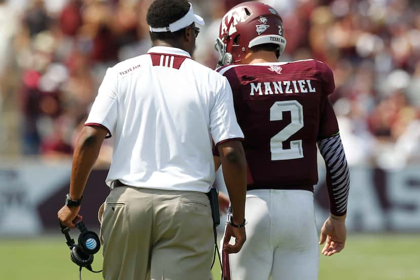 Texas A&M Aggies coach Kevin Sumlin talks to Texas A&M Aggies quarterback Johnny Manziel (2)...