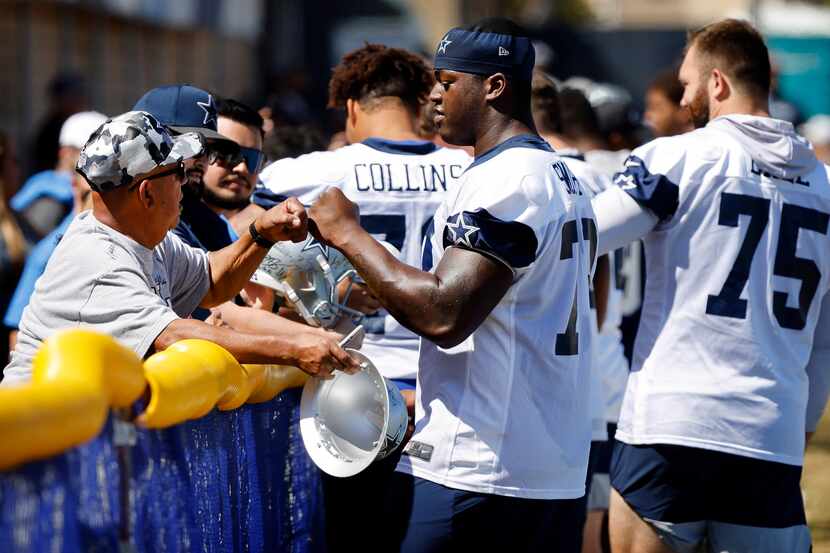 Dallas Cowboys rookie offensive tackle Tyler Smith (73) gives a fist bump to a volunteer...