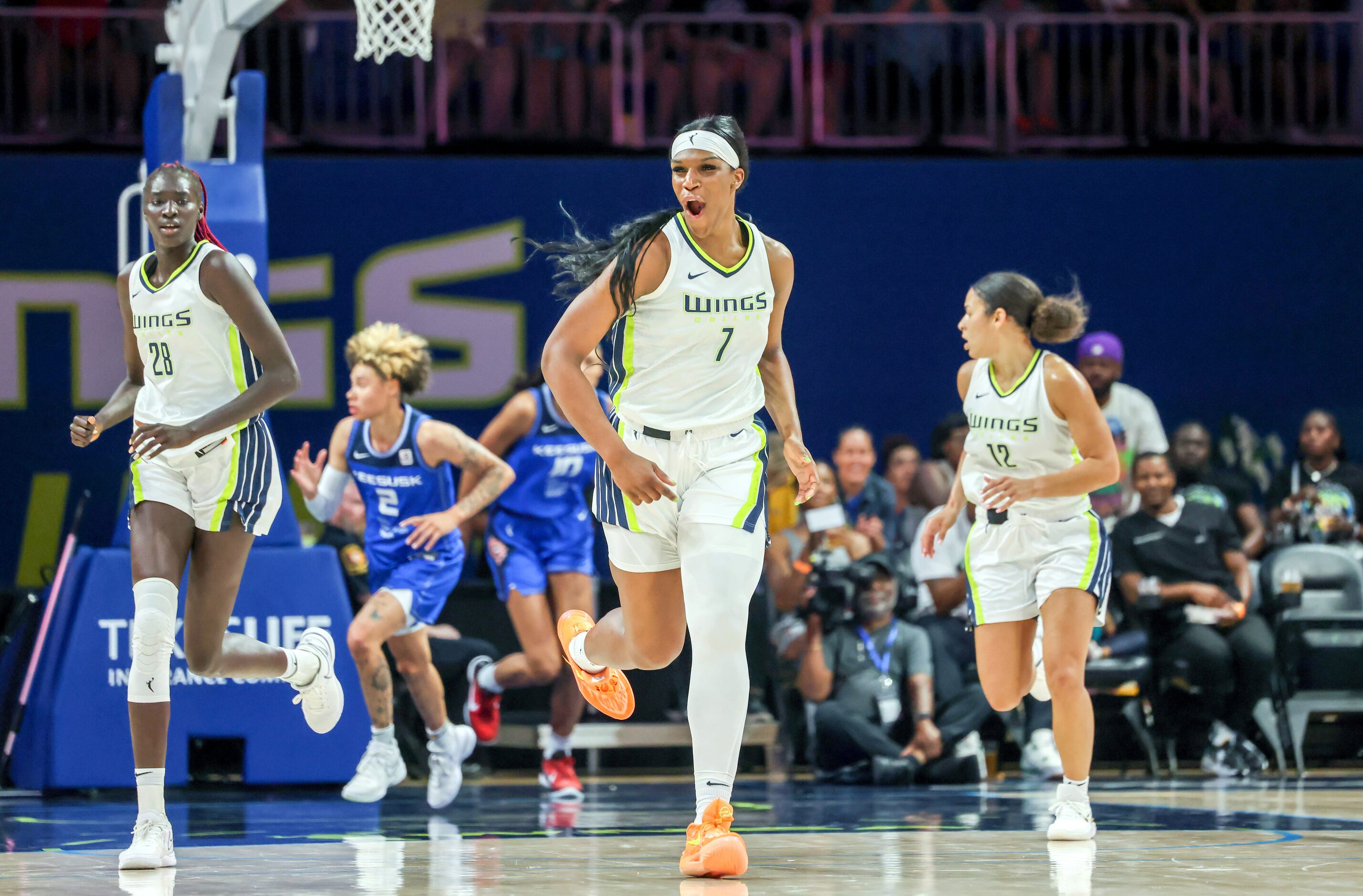 Dallas Wings center Teaira McCowan (7) cheers for a score by the Wings while running across...