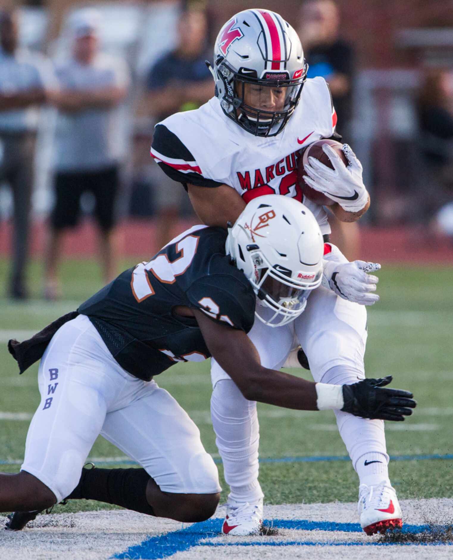 Arlington Bowie defensive back Tre Martin (22) tackles Flower Mound Marcus running back...