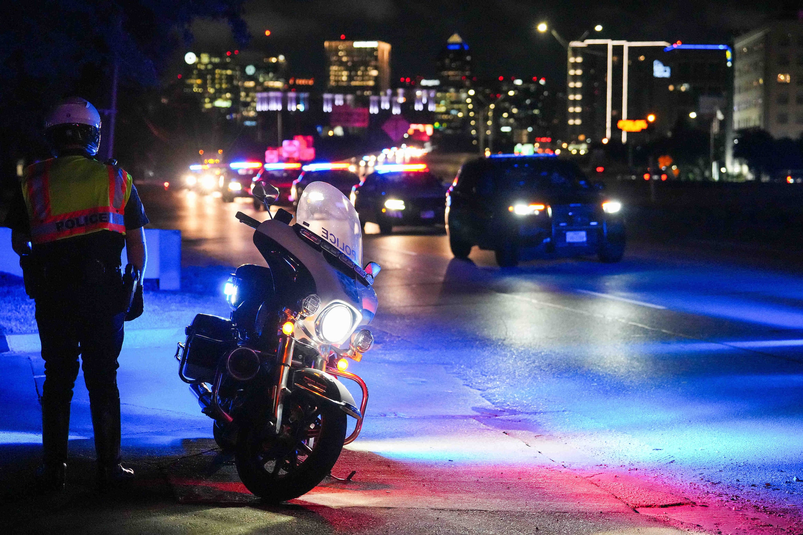 A procession of Dallas police vehicles exits the Stemmons Fwy near the medical examiner’s...