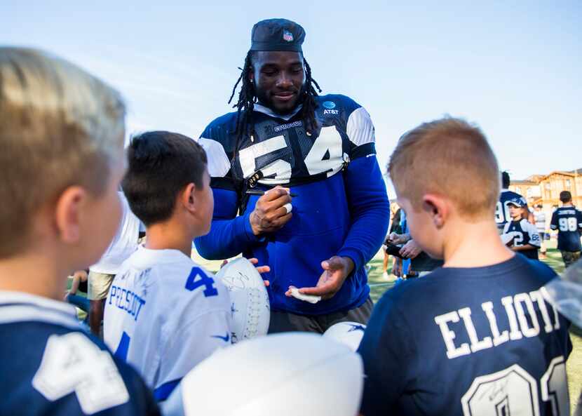 Dallas Cowboys middle linebacker Jaylon Smith (54) signs autographs for players on the flag...