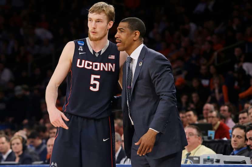 Connecticut's Niels Giffey, of Germany, and head coach Kevin Ollie talk during the second...
