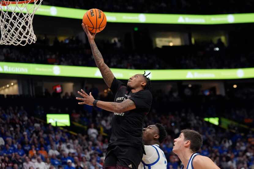 Texas A&M guard Wade Taylor IV (4) goes up for a shot as Kentucky's Reed Sheppard (15) and...