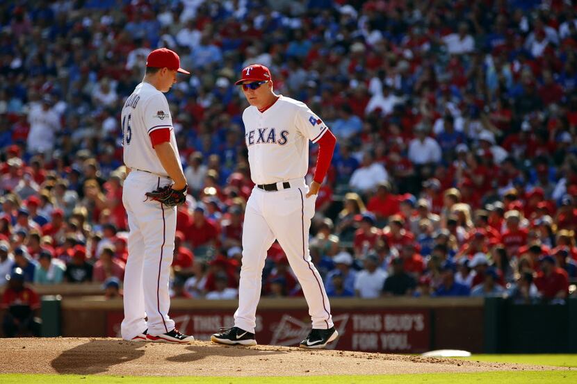 Texas Rangers starting pitcher Derek Holland (45) receives a second inning visit to the...