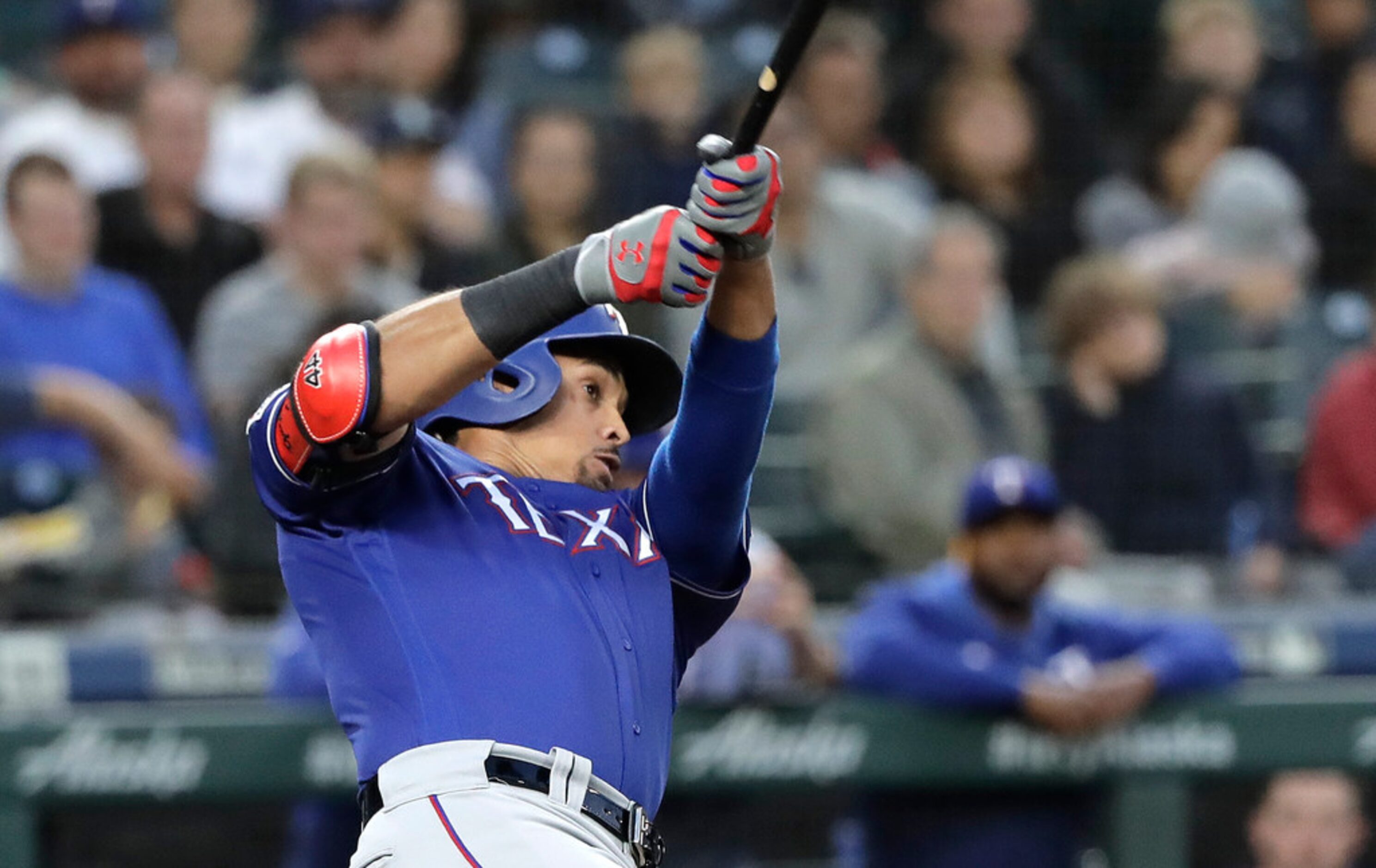 Texas Rangers' Ronald Guzman follows through on a three-run home run during the fifth inning...