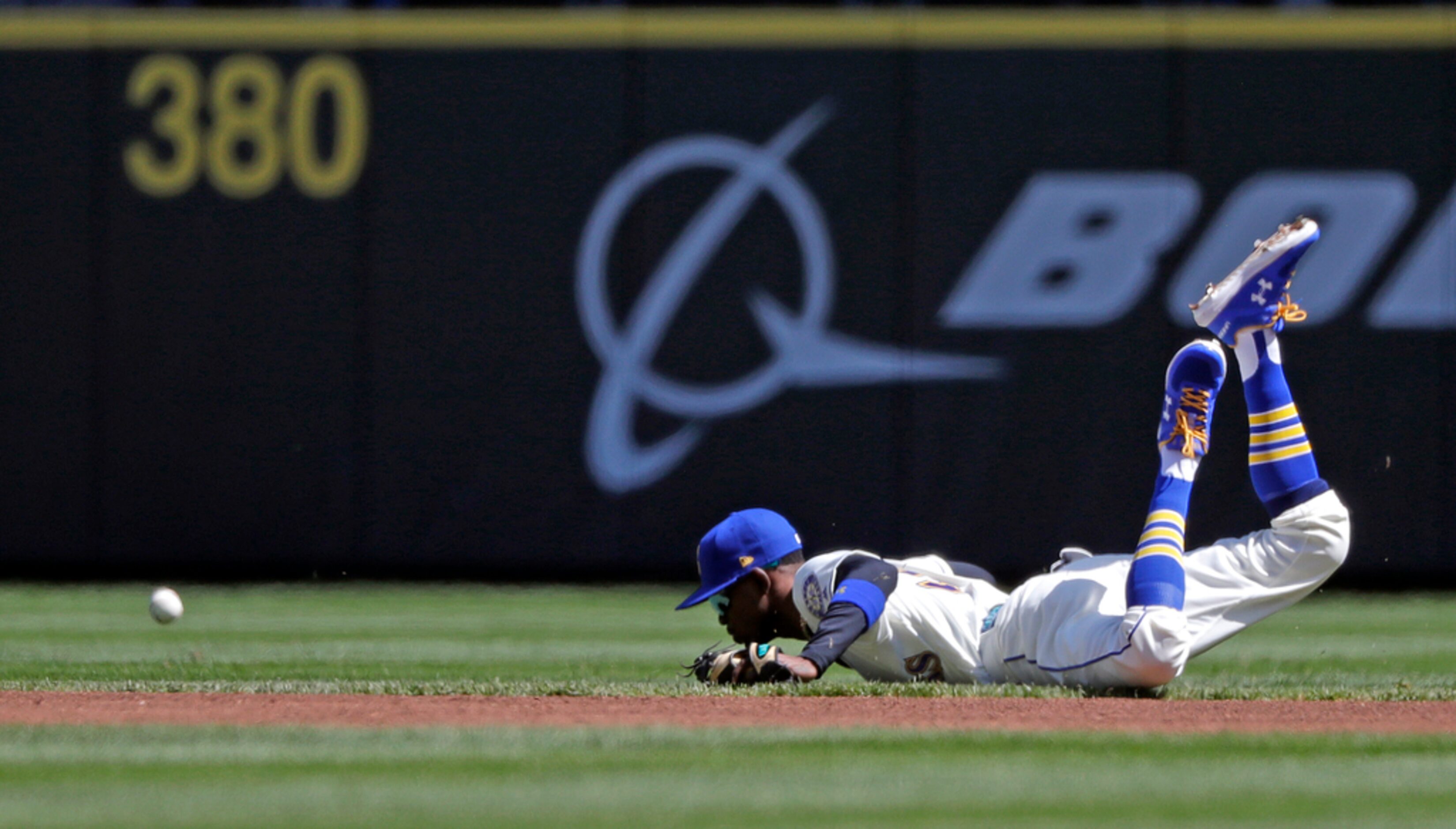 Seattle Mariners second baseman Dee Gordon winds up on the dirt after diving for a single...