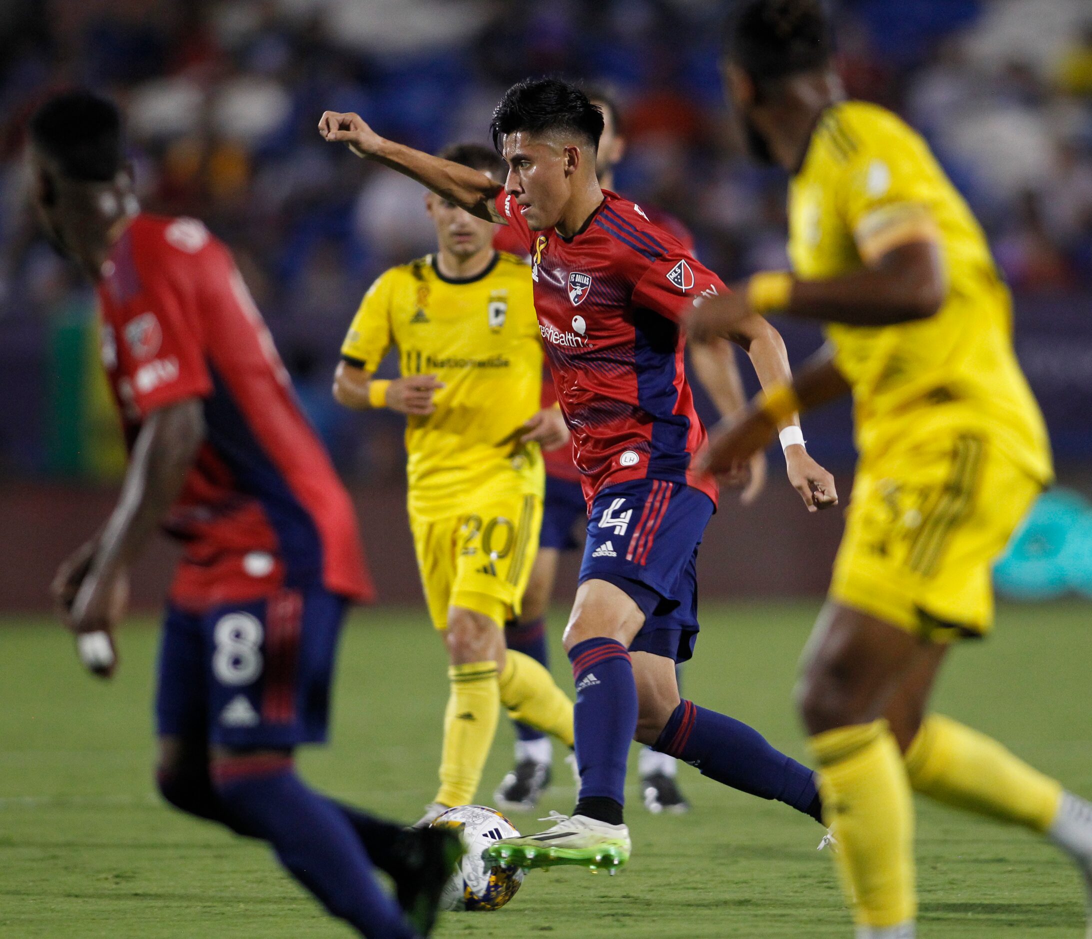 FC Dallas defender Marco Farfan (4) maneuvers the ball through traffic during the first half...